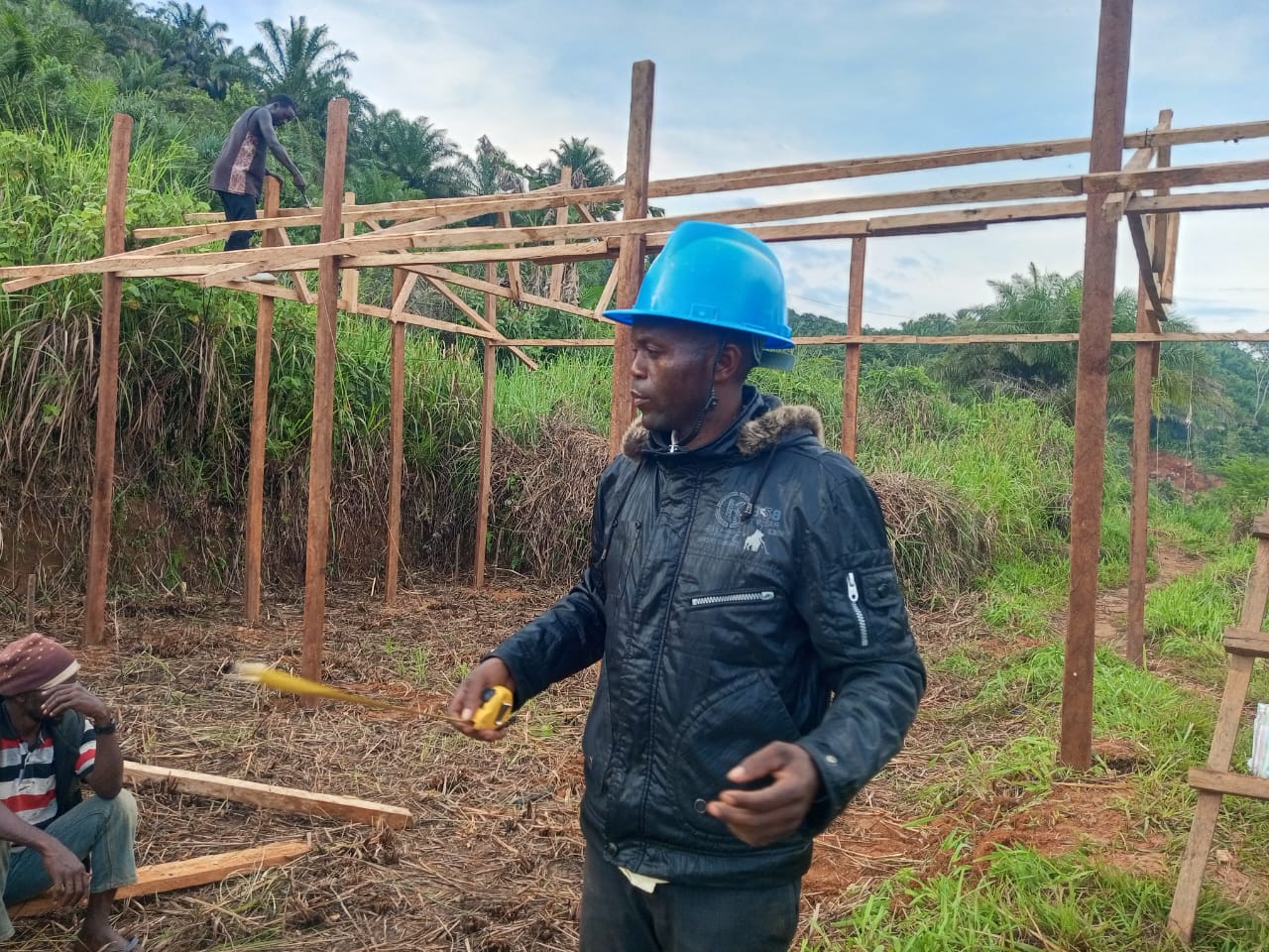 Gangala Yafali Mangusa Jr. is betrokken bij de bouw van een gemeenschappelijk kippenhok in het productiegebied van Bamasubha Local Community Forest Concession (CFCL), in het oosten van de Democratische Republiek Congo. Afbeelding door Jéremie Kyaswekera Kakule.