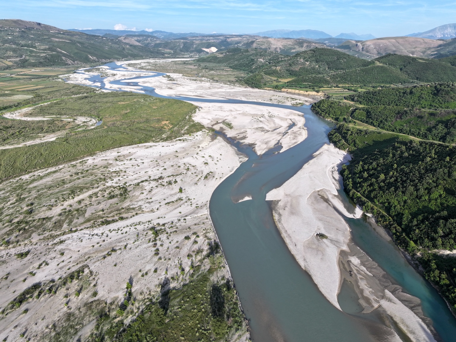 De Vjosa-rivier vlecht zich vrijelijk over een brede uiterwaarden van grind in het zuiden van Albanië. De Vjosa is een van de laatste grote rivieren in Europa die geheel ongehinderd door dammen stroomt. Afbeelding door Stefan Lovgren voor Mongabay.