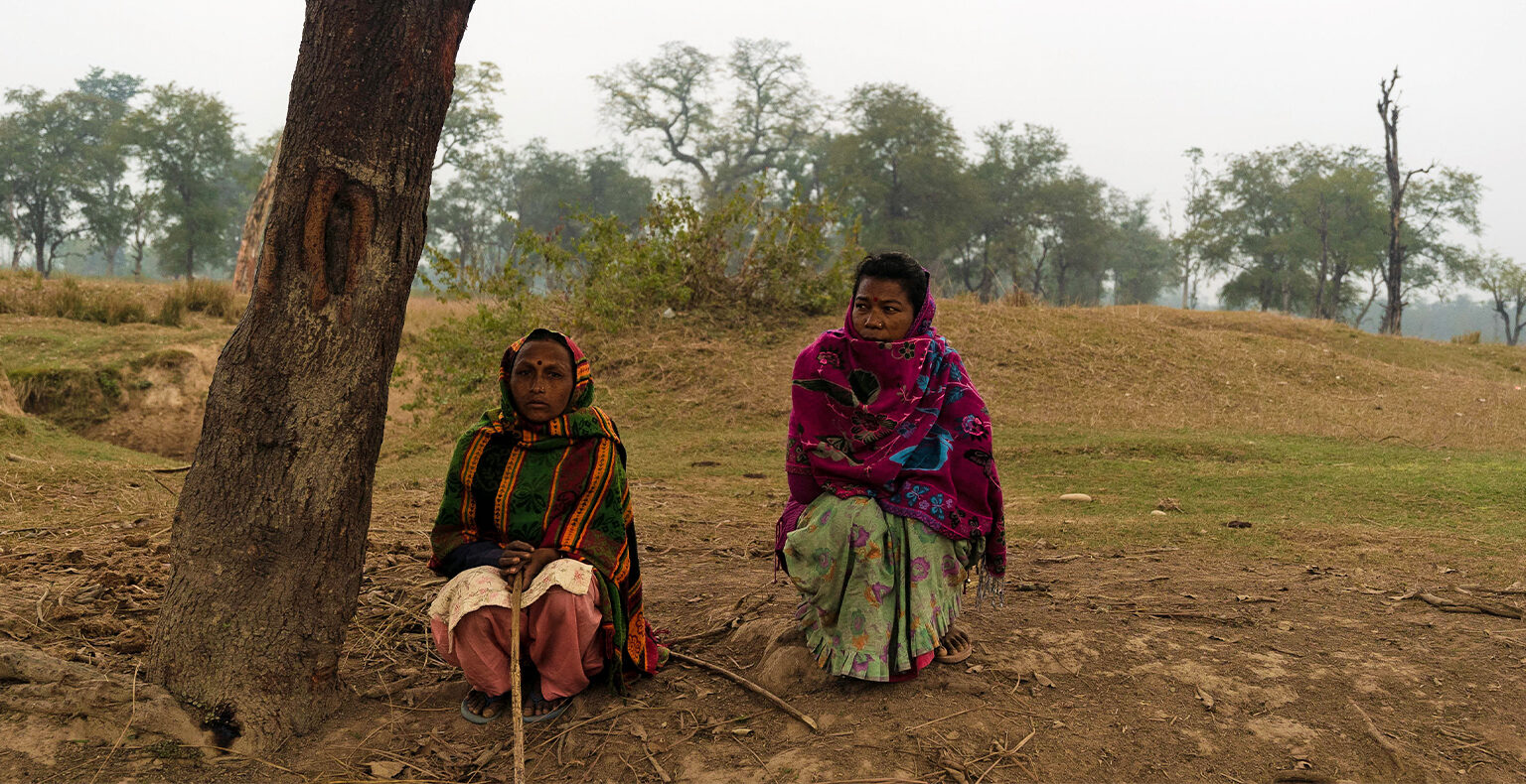 Afbeelding van vrouwen die voor hun vee zorgen aan de rand van Bardiya National Park.