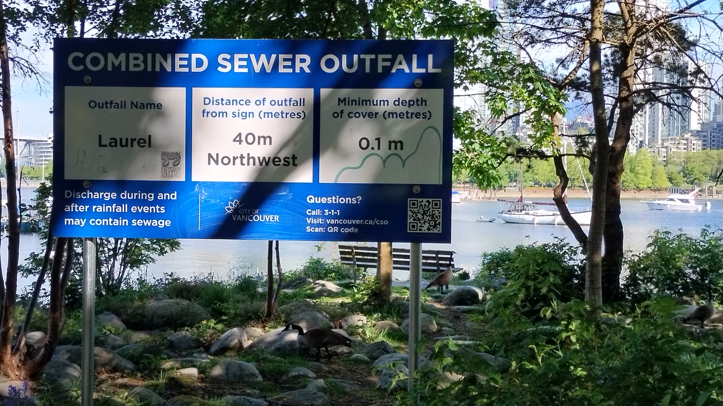 Een bord waarschuwt voor een afvoerpijp waardoor tijdens hevige regenval ongezuiverd rioolwater False Creek in stroomt. Afbeelding door Jennifer Cole voor Mongabay. 
