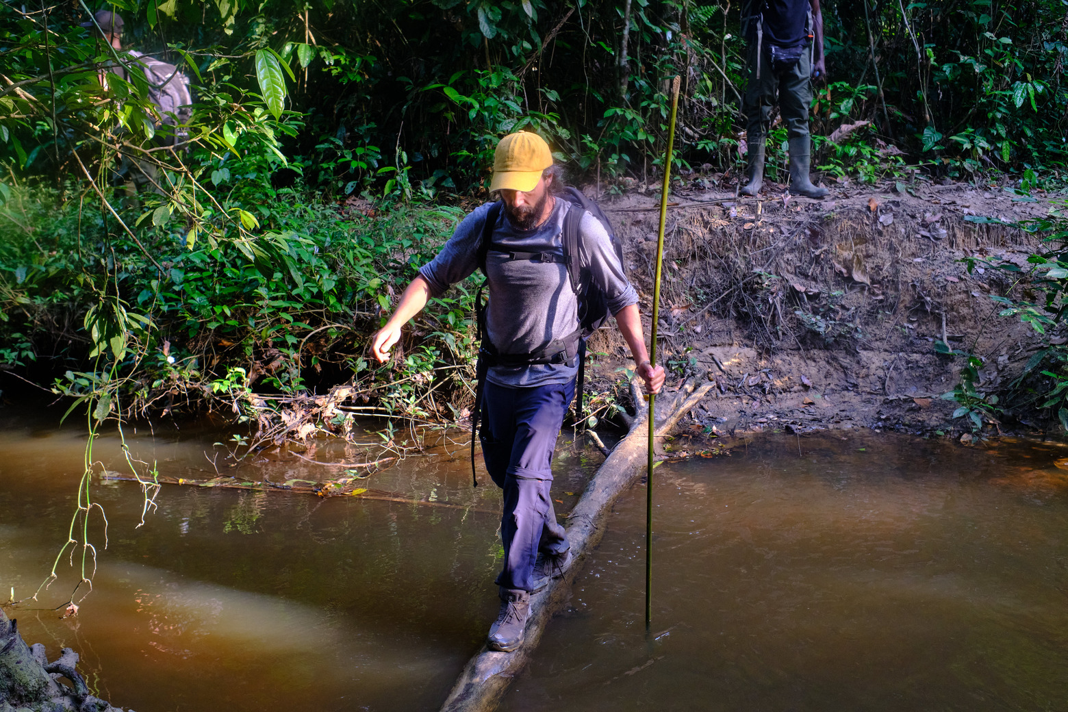 Mongabay-producent Juan Maza steekt een rivier over in het voorgestelde Kwa National Park in Grand Gedeh, Liberia. Foto door Ashoka Mukpo voor Mongabay.
