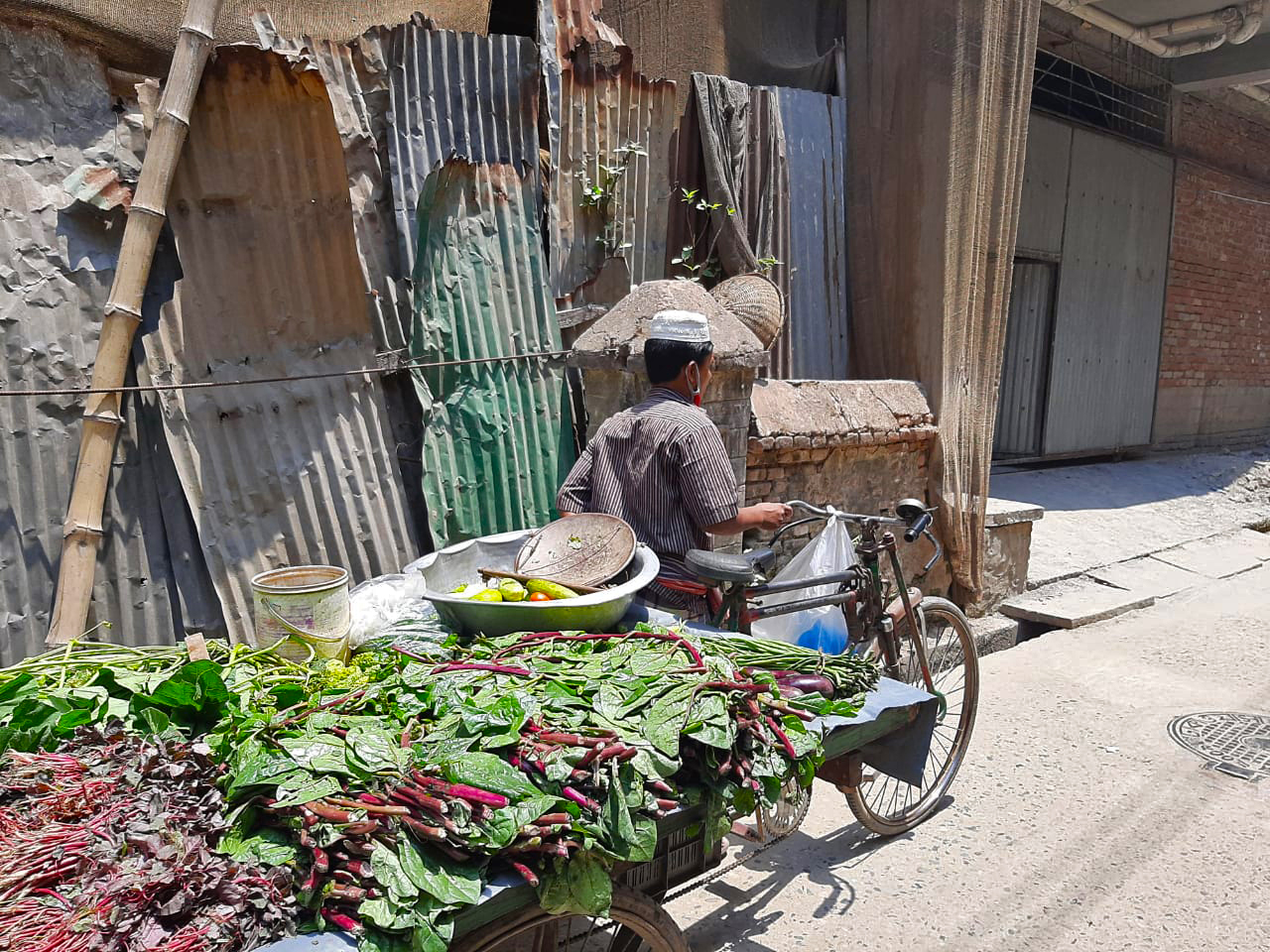 Een man verkoopt groenten op een warme dag in Bangladesh. Afbeelding door BDRCS / Climate Center via Flickr (CC BY-NC 2.0).