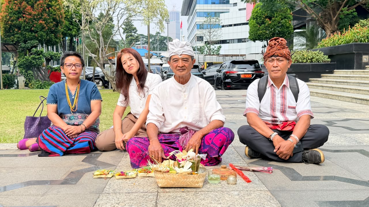 AMAN-secretaris-generaal Rukka Sombolinggi, links, zit met vertegenwoordigers van de inheemse volkeren I Putu Ardana, vooraan in het midden, en Herman Sarira, rechts, bij het Constitutionele Hof in Jakarta op 8 juli 2026. Afbeelding met dank aan AMAN.