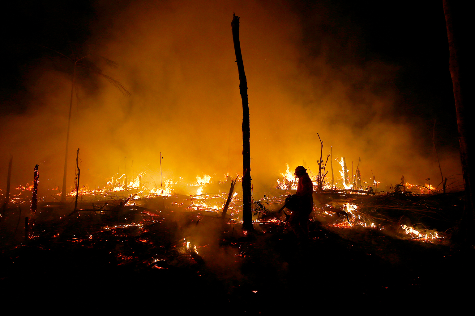 Brandweerlieden zijn bezig met het blussen van een brand in het Amazonewoud tijdens droogte en hoge temperaturen in de landelijke gemeente Careiro Castanho, in de staat Amazonas, Brazilië. Afbeelding door AP Photo / Edmar Barros.