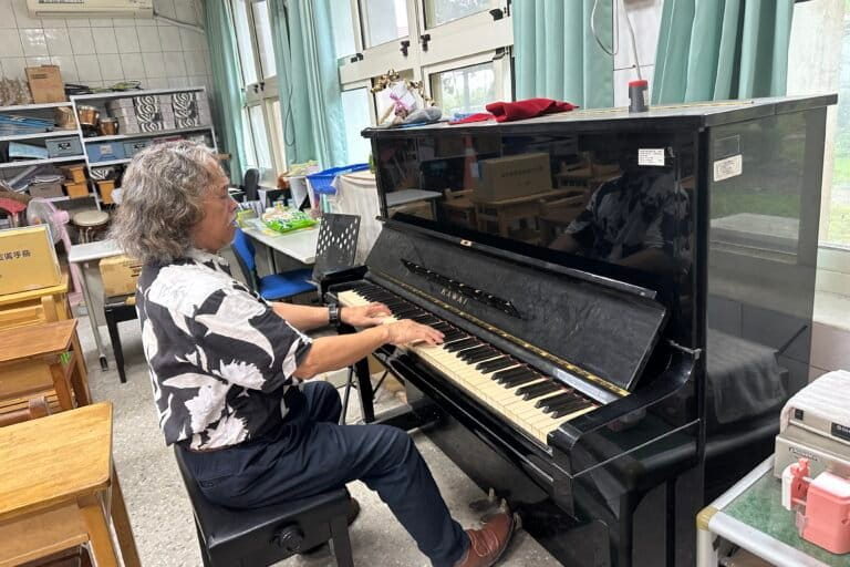 De in Filipijnen geboren Siraya-activist en muzikant Edgar Macapili speelt piano in een klaslokaal op de Koupi Experimental Elementary School in het Sinhua-district, Tainan, 21 augustus 2026. Afbeelding door Aylin Ho voor Mongabay.