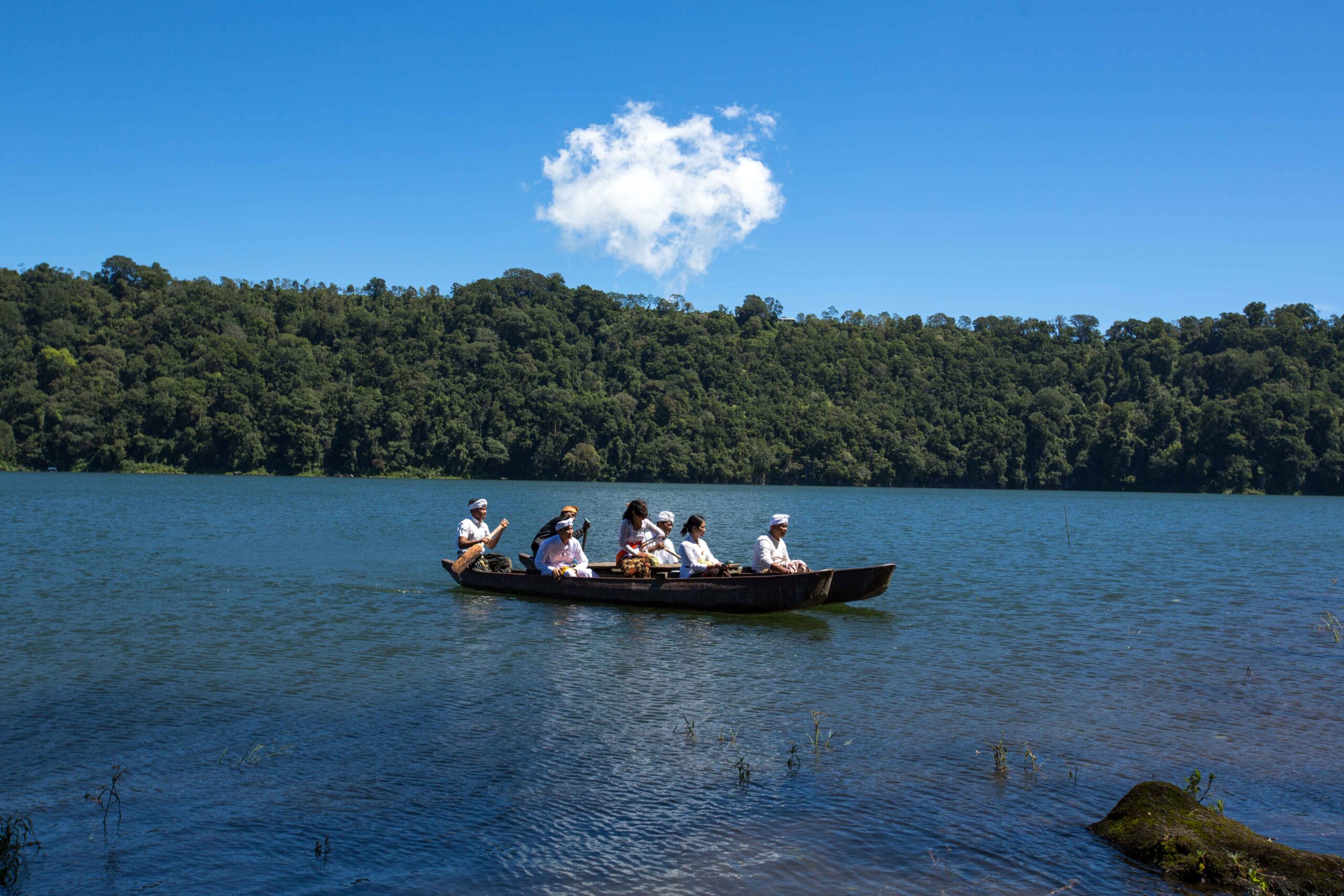 Dalem Tamblingan Leden van de inheemse gemeenschap reizen per boot over een meer om Pura Dalem Tamblingan te bereiken, een hindoetempel in het heilige Mertajati-woud op Bali. 