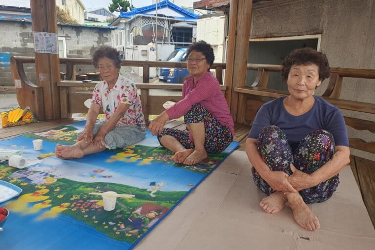 Haenyeo en beste vrienden, van links naar rechts, Lee Yeon-oak, Im Gil-seok en Kim Choon-hee, in een prieel aan de kust in Guman-ri, Zuid-Korea, op 16 augustus 2026.