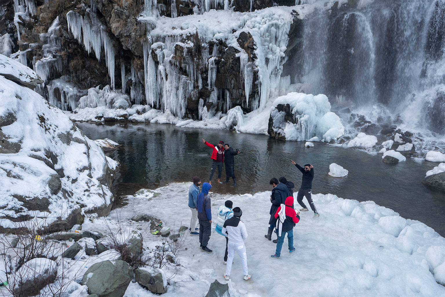 Toeristen bezoeken een gedeeltelijk bevroren waterval in het dorp Drang, ten noordwesten van Srinagar. 