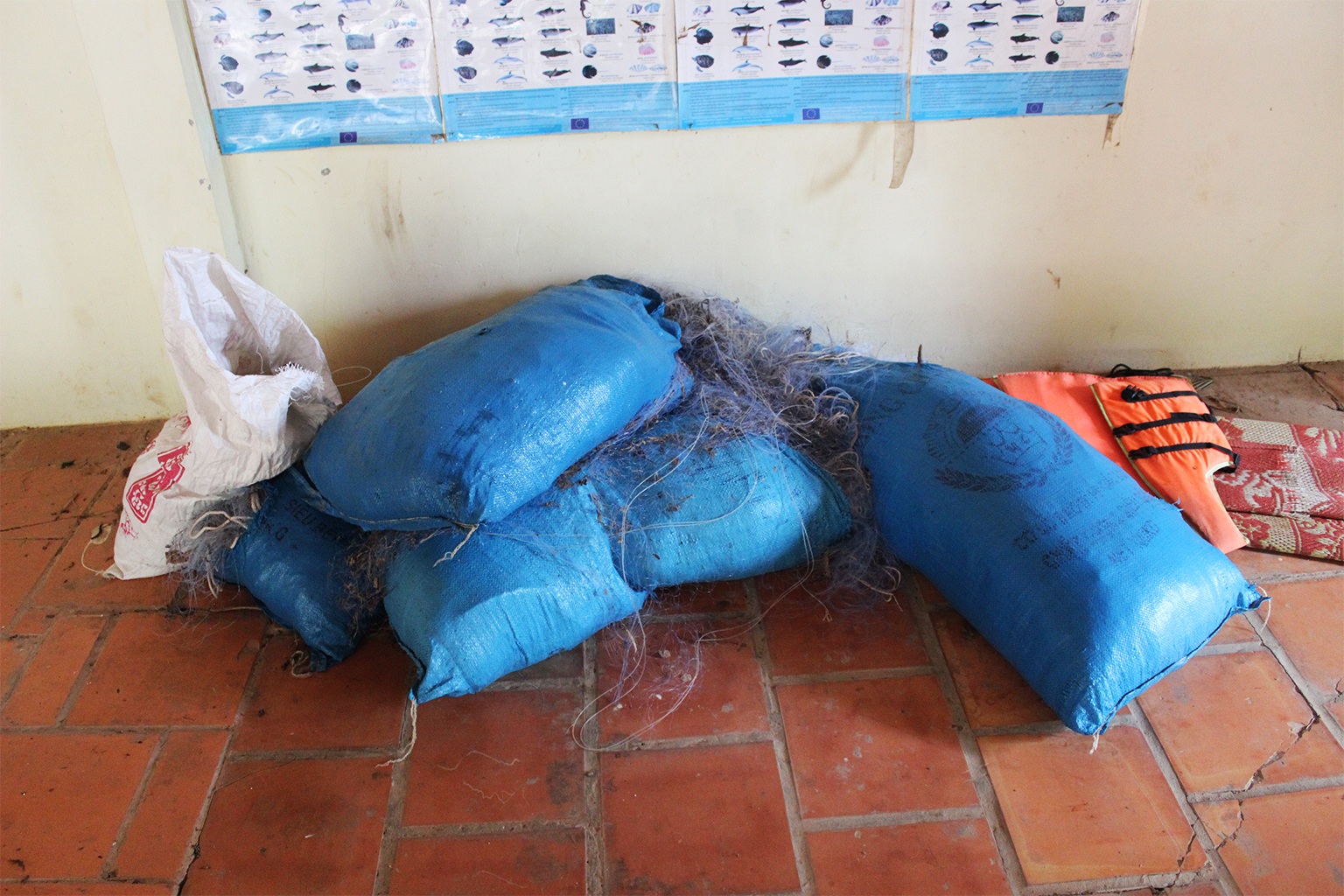 Kieuwnetten die in beslag zijn genomen uit de habitatzone van de Kampi-dolfijnenpoel liggen op stapels in een patrouillestation.