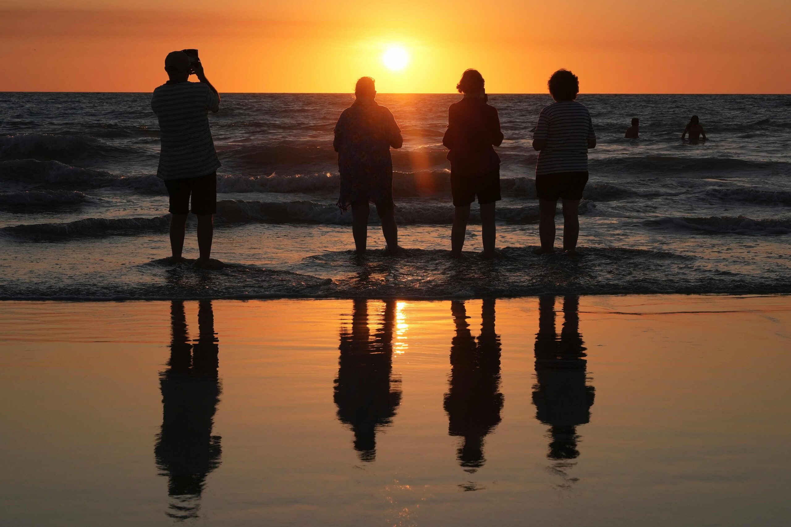 Mensen kijken toe hoe de zon ondergaat bij Cable Beach in Broome, West-Australië, zaterdag 22 augustus 2026. Afbeelding door AP Photo/Mark Baker.