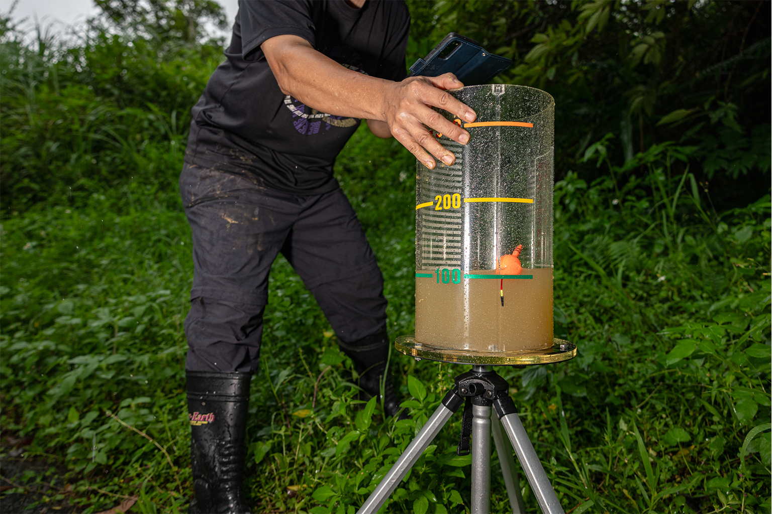 Chen-Lung Chien meet de regenval op de nieuw aangelegde experimentele theeplantage, die de naam Ri Ri Ri Shin Tea Plantation zal krijgen, in het district Shenkeng, Taiwan. Hoewel de algehele regenval in de regio optimaal blijft, valt deze nu in intensere stormen, gevolgd door perioden van hitte en droogte. Als reactie hierop heeft de regio meer droogteresistente theesoorten in Shenkeng geïntroduceerd om het aanpassingsvermogen van theeplantages aan de klimaatverandering te vergroten. Afbeelding door Michael O. Snyder voor Mongabay.