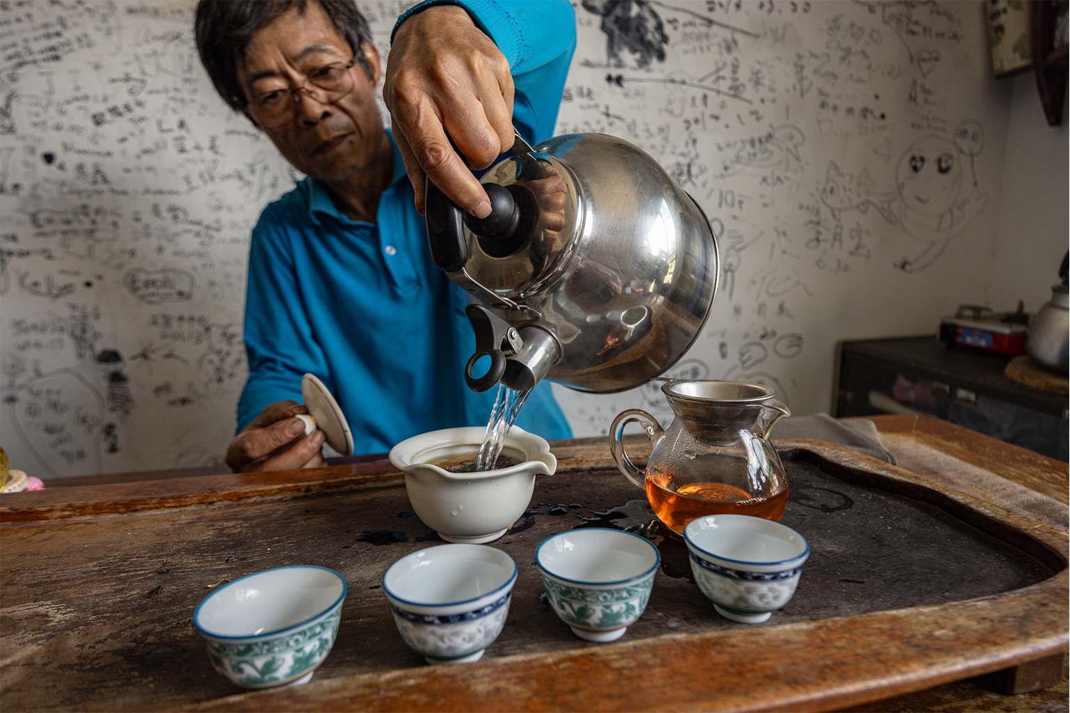 Ri-Shan Zeng serveert middagthee in een serveerkamer op de plantage van zijn familie in het district Shenkeng, Taiwan. De familie Zeng is al vier generaties lang eigenaar van deze theeplantage. Afbeelding door Michael O. Snyder voor Mongabay.