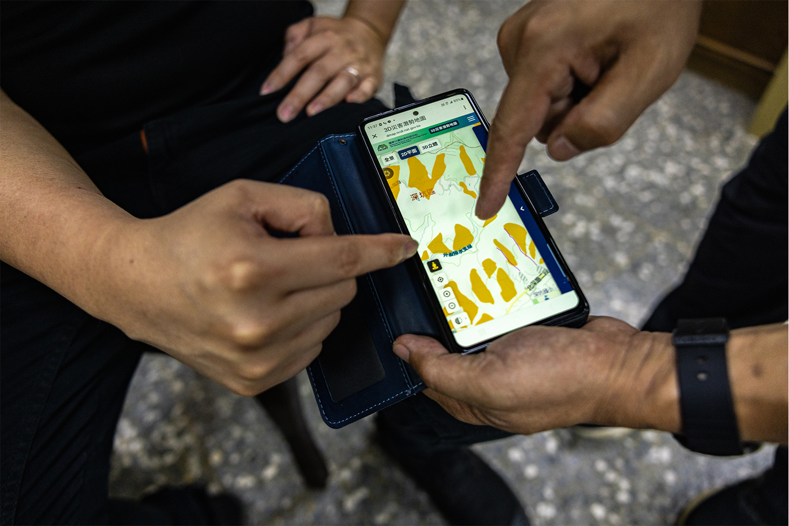 Chao-Shiang Li en Chen-Lung Chien demonstreren het gebruik van een nieuwe app die de hellingen van de theeplantages van Shenkeng laat zien en zones illustreert die een hoog risico lopen op aardverschuivingen, die steeds vaker voorkomen bij krachtigere tyfonen. Afbeelding door Michael O. Snyder voor Mongabay.