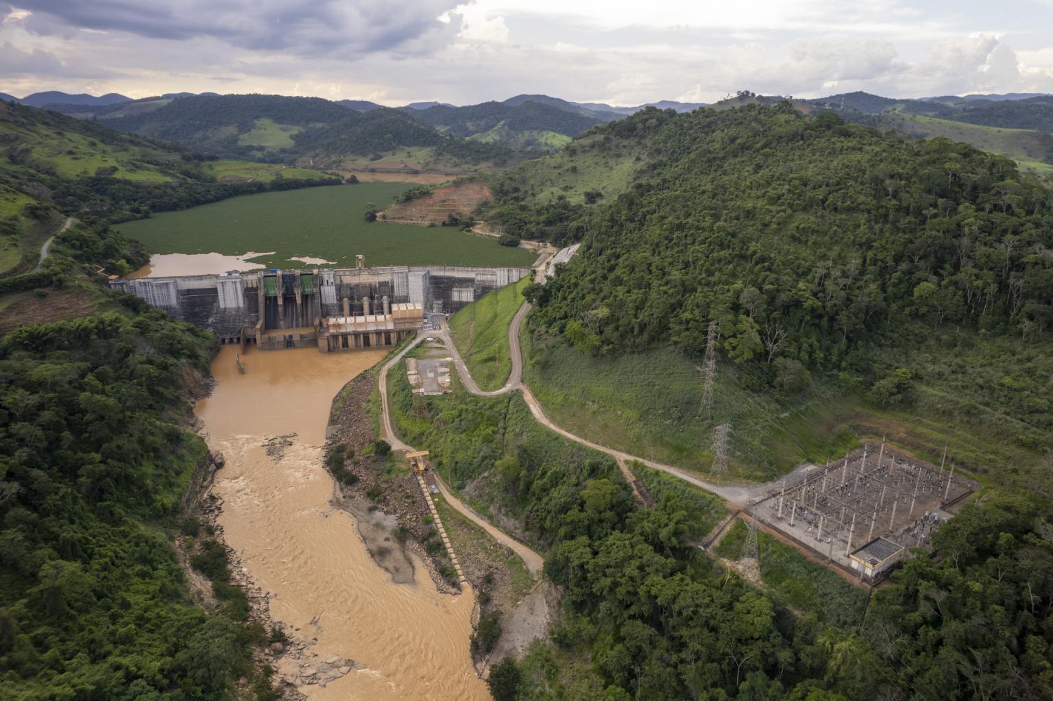 Luchtfoto van de Fundão-dam, omringd door groene bergen in Minas Gerais, Brazilië, die in 2015 – bekend als de Mariana-damramp – leidde tot een van de grootste gevallen van besmetting met minerale residuen ooit geregistreerd. De giftige modder sijpelde de grond in, vervuilde het grondwater en reisde via de Doce-rivier 668 kilometer (415 mijl) naar de Atlantische Oceaan.