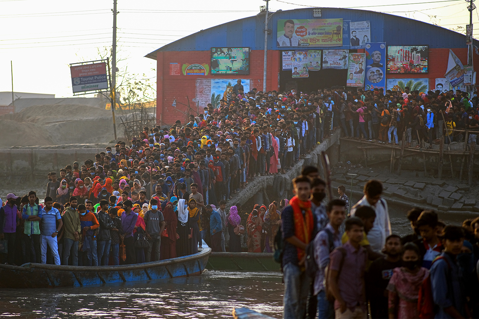 Werknemers verzamelen zich 's ochtends bij een bootterminal, wachtend om de Mongla-rivier in Mongla, Bangladesh, maart 2022 over te steken. 