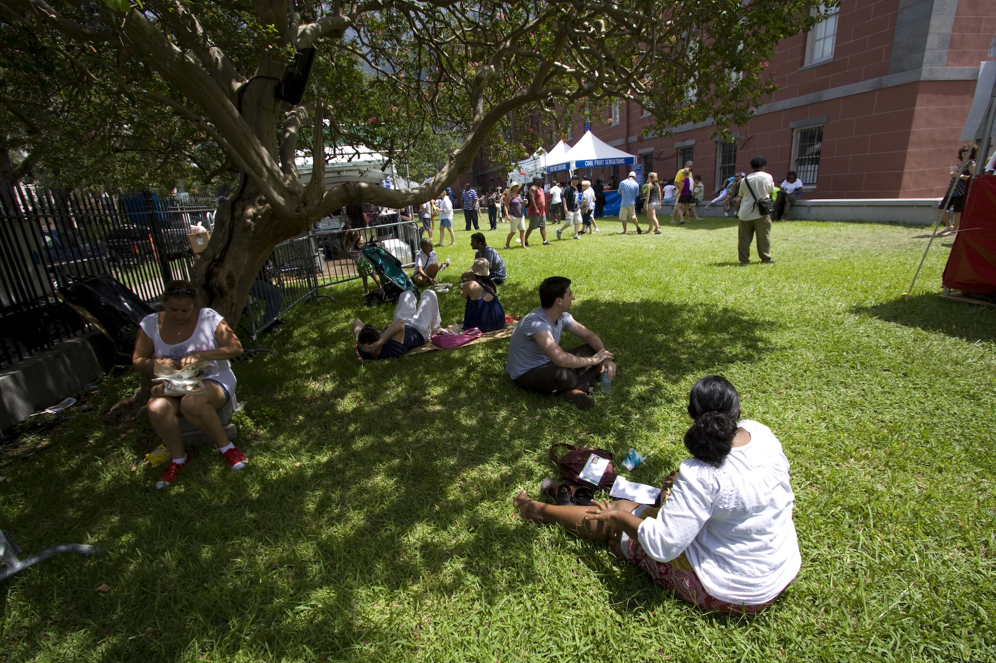 Festivalgangers zoeken de schaduw op tijdens een warme zomerdag in de zuidelijke stad New Orleans. Afbeelding door Derek Bridges via Wikimedia Commons (CC BY 2.0).