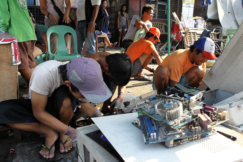 Bewoners ontmantelen apparaten langs Capulong Street in Tondo, Manilla, Filipijnen. Afbeelding © Greenpeace.